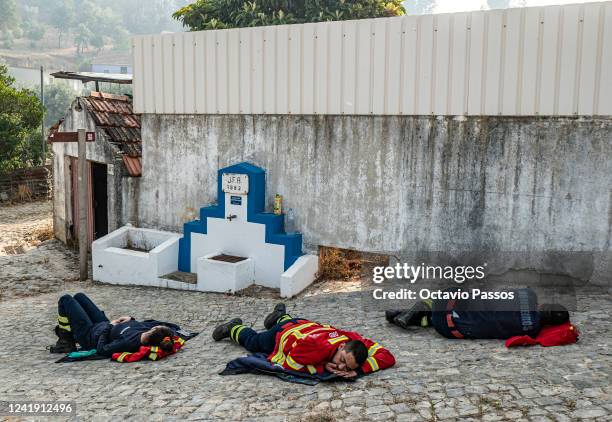 This photograph shows firefighters resting on ground after spending the night on shift in the mountains of Alvaiazere on July 15, 2022 in Alvaiazere,...