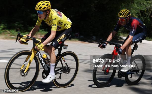 Jumbo-Visma team's Danish rider Jonas Vingegaard wearing the overall leader's yellow jersey cycles ahead of Ineos Grenadiers team's British rider...