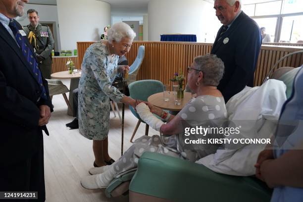 Britain's Queen Elizabeth II shakes hands with patient Pat White during a visit to officially open the new building of Thames Hospice in Maidenhead,...
