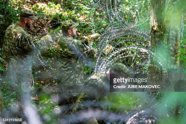 Members of the Slovenian Army disassemble a barbed wire fence at the Slovenian-Croatian border, close to the small village of Krmacina, Slovenia, on...