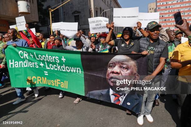 Disgruntled members of the ruling African National Congress march to Luthuli House, their headquarters holding a poster reflecting the face of South...