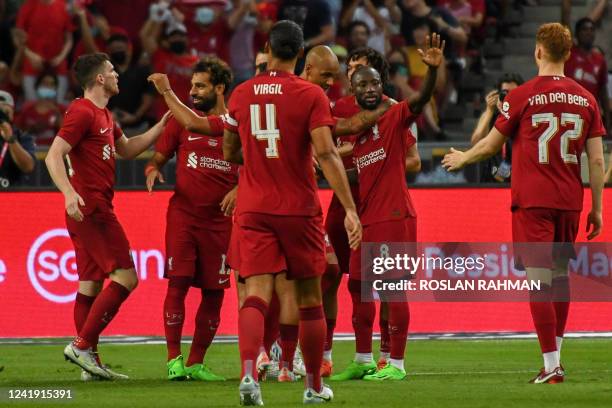 Liverpool's Egyptian forward Mohamed Salah celebrates with teammates after scoring during the exhibition football match between English Premier...