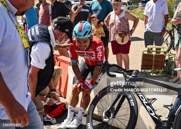 Lotto Soudal team's Australian rider Caleb Ewan receives medical attention after suffering a crash during the 13th stage of the 109th edition of the...