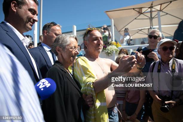 France's Prime Minister Elisabeth Borne poses for a selfie picture with a holiday maker during a meeting with officials from national police,...