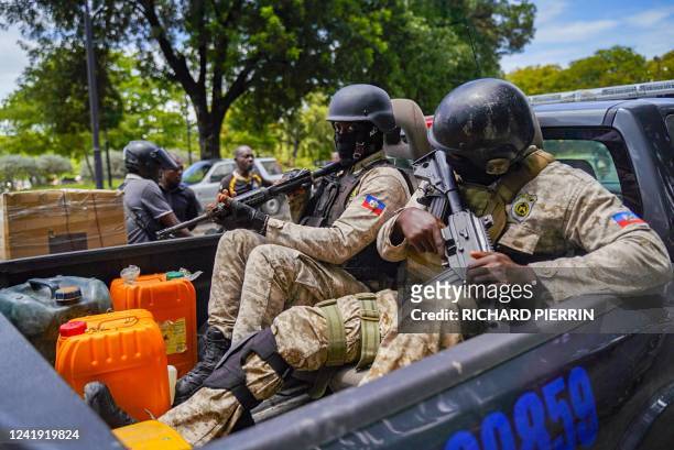 Haitian police collect fuel as they patrol in Port-au-Prince on July 15, 2022. - With gas sales already subsidized by the government at a loss, the...