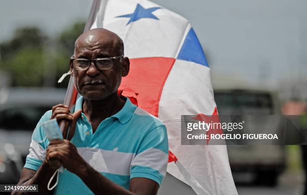 Man holds a Panamanian flag during a blockade of the Pan-American highway in Aguadulce, Panama, on July 15, 2022. Protests continue against rising...