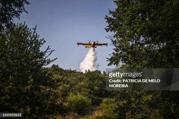 Firefighter plane drops water at a forest fire near the village of Eiriz in Baiao, north of Portugal, on July 15, 2022.