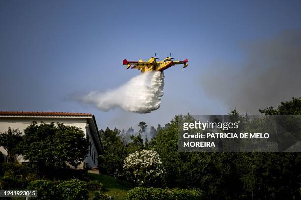 Firefighter plane drops water at a forest fire near the village of Eiriz in Baiao, north of Portugal, on July 15, 2022.