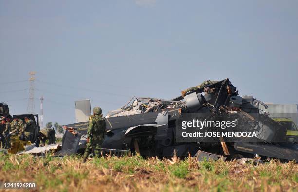 Soldiers of the Mexican Army inspect the wreckage of a Navy helicopter that crashed near the airport of Los Mochis, Sinaloa State, Mexico on July 15,...