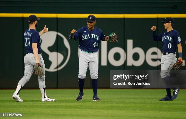 Julio Rodriguez of the Seattle Mariners celebrates with teammates Jesse Winker and Sam Haggerty after the Mariners defeated the Texas Rangers 8-3 at...