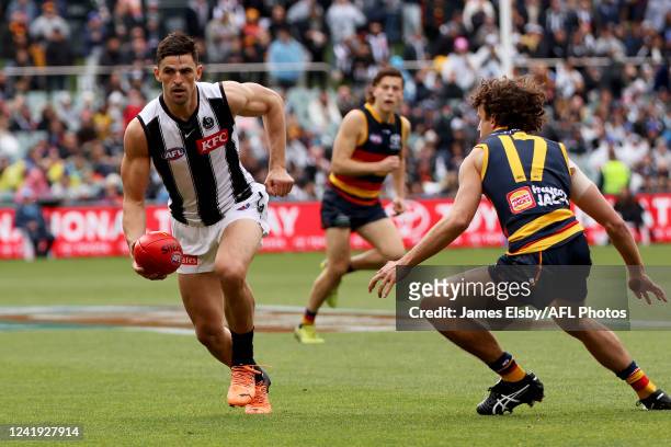Scott Pendlebury is tackled by Will Hamill of the Crows during the 2022 AFL Round 18 match between the Adelaide Crows and the Collingwood Magpies at...