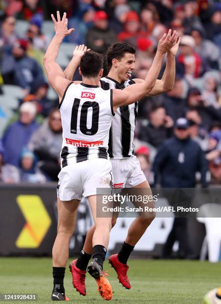 Nick Daicos of the Magpies celebrates a goal with Scott Pendlebury during the 2022 AFL Round 18 match between the Adelaide Crows and the Collingwood...