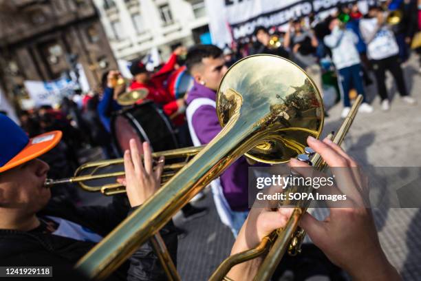The National Congress is reflected on a trumpet of a protester from the Picketer Unit, as other protesters sing protest songs during the...