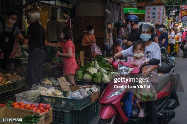 People ride on scooters to buy foods at a wet market on July 6, 2022 in Taipei, Taiwan. Taiwan has an average of 607 scooters for every 1,000 people,...