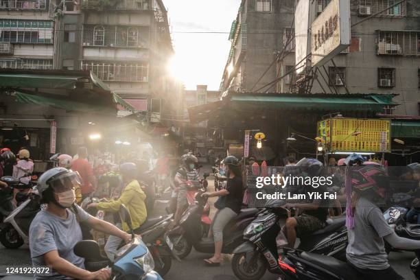 People ride on scooters to buy foods at a wet market on July 6, 2022 in Taipei, Taiwan. Taiwan has an average of 607 scooters for every 1,000 people,...