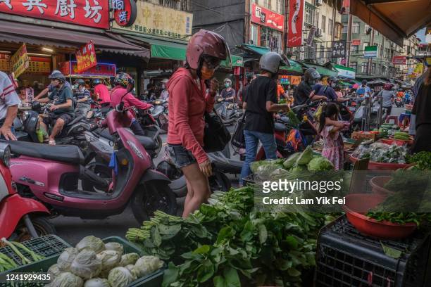 People ride on scooters to buy foods at a wet market on July 6, 2022 in Taipei, Taiwan. Taiwan has an average of 607 scooters for every 1,000 people,...