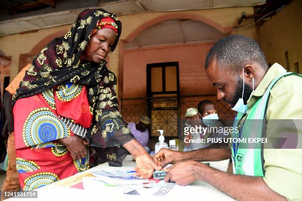 An official of the Independent National Electoral Commission registers a voter at a polling station during the gubernatorial election at Ede in Osun...