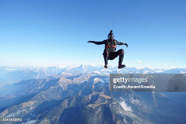 skydiver falls through clear skies, aerial flight - aerial stunts flying stock pictures, royalty-free photos & images