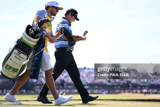 Golfer Patrick Reed and his caddie leave the 2nd tee during his third round on day 3 of The 150th British Open Golf Championship on The Old Course at...