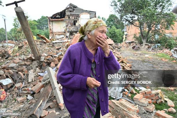 Local resident, Raisa Kuval reacts next to a damaged building partially destroyed after a shelling in the city of Chuguiv, east of Kharkiv, on July...