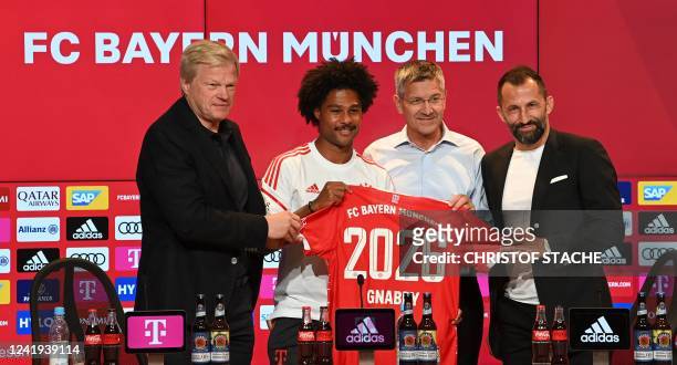 Bayern Munich's German midfielder Serge Gnabry poses with Bayern Munich's CEO Oliver Kahn Bayern Munich's President Herbert Hainer and Bayern...