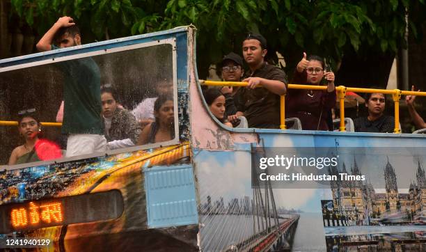 Youngsters enjoy the rain taking a "Joy Ride" in the open MTDC's BEST Bus at Chhatrapati Shivaji Maharaj Terminus, on July 16, 2022 in Mumbai, India.