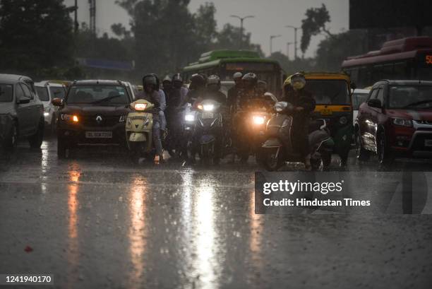 Commuters in heavy rain at Delhi Gatej, on July 16, 2022 in New Delhi, India. Heavy rainfall lashed Delhi and its adjoining areas on Saturday,...