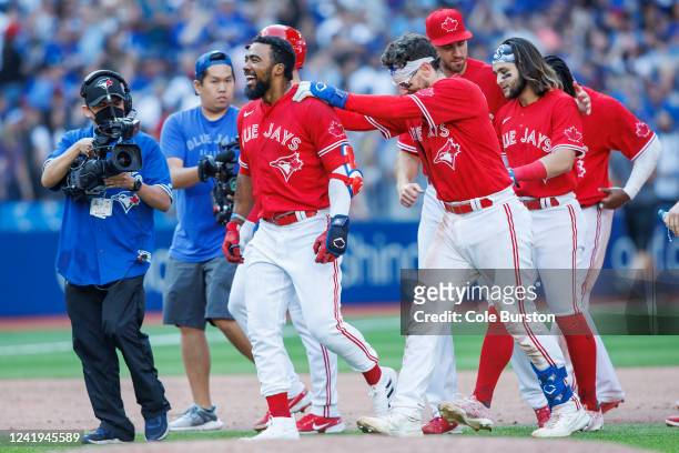 Teoscar Hernandez of the Toronto Blue Jays is mobbed by teammates as they celebrate his walk-off RBI single against the against the Kansas City...