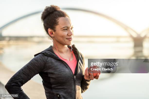 sporty woman takes care of her health. - adult female eating an apple stock pictures, royalty-free photos & images
