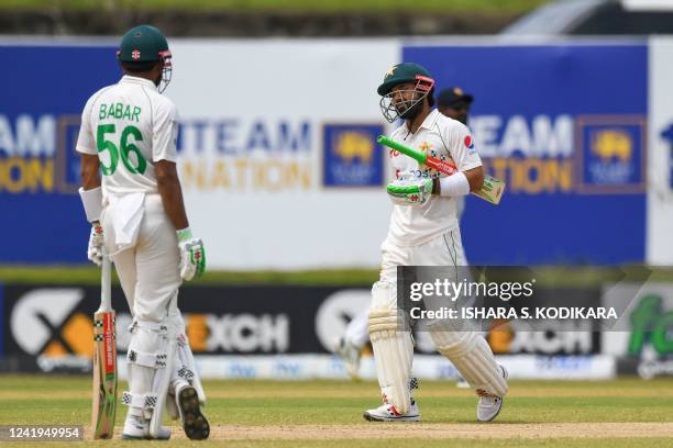 Pakistans Mohammad Rizwan walks back to the pavilion after his dismissal as his captain Babar Azam watches during the second day of the first cricket...