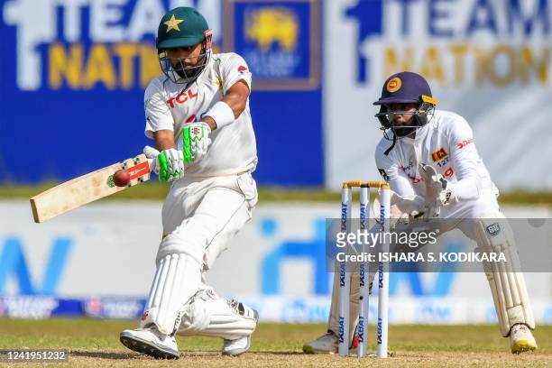 Pakistans captain Babar Azam plays a shot as Sri Lanka's wicketkeeper Niroshan Dickwella watches during the second day of the first cricket Test...