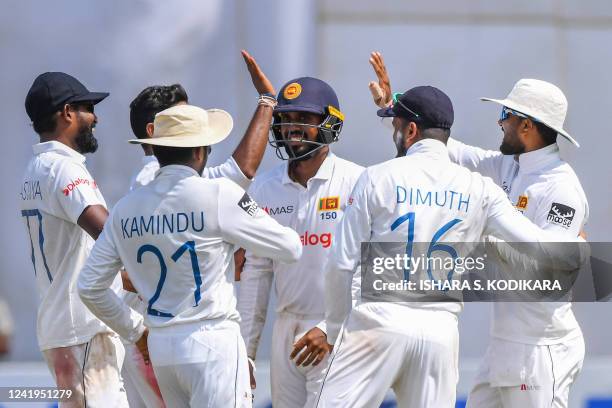 Sri Lanka's Dinesh Chandimal celebrates with teammates after taking the wicket of Pakistans Hasan Ali during the second day of the first cricket Test...