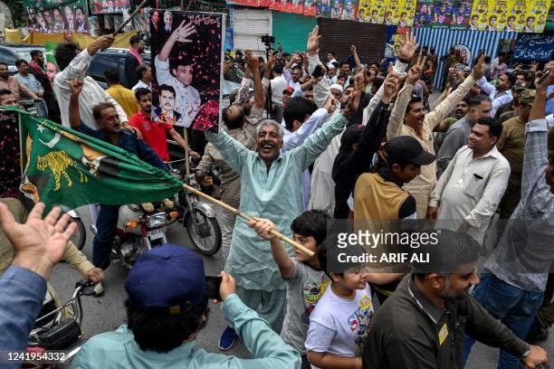 Political activists shout slogans outside a polling station during the by-election in Punjab province assembly seat in Lahore on July 17, 2022.