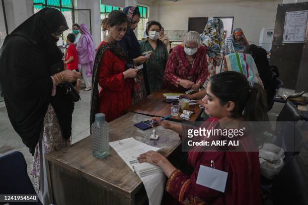 Voters arrive to cast their ballot at a polling station during the by-election in Punjab province assembly seat in Lahore on July 17, 2022.