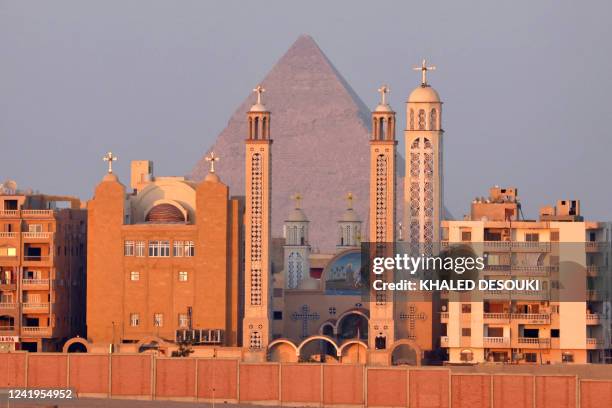 Picture taken on July 13, 2022 shows blessed Virgin Mary Church and St. Anba Reweiss at Ahram Gardens district with the Great Pyramids at the Giza...