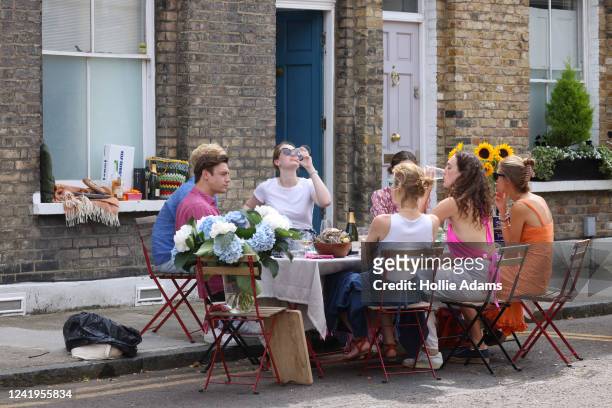 People drink and dine on the street in Hackney on July 17, 2022 in London, England. While some Britons flocked to the seaside to beat the current...
