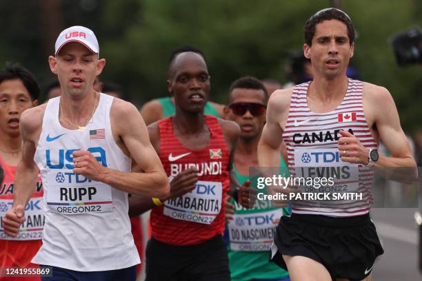 S Galen Rupp runs beside Canada's Cameron Levins in the men's marathon final during the World Athletics Championships in Eugene, Oregon on July 17,...