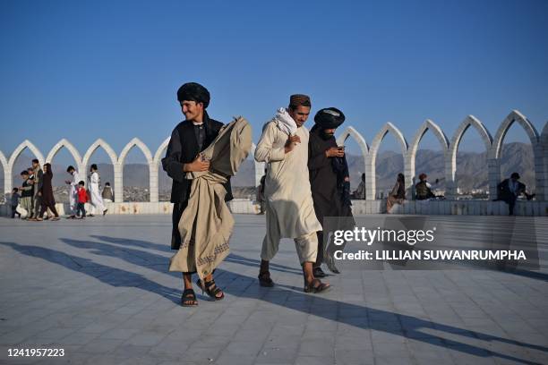 Men walk around at Wazir Akbar Khan Hill in Kabul on July 17, 2022.