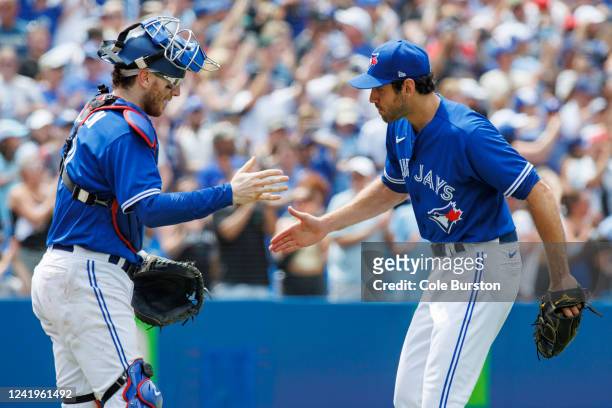 Jordan Romano and Danny Jansen of the Toronto Blue Jays react after recording the final strike-out of their MLB game victory over the Kansas City...