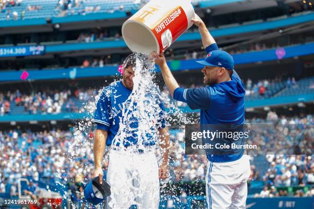 Jordan Romano of the Toronto Blue Jays gets water poured overtop of him by David Phelps during his post-game interview after defeating the Kansas...