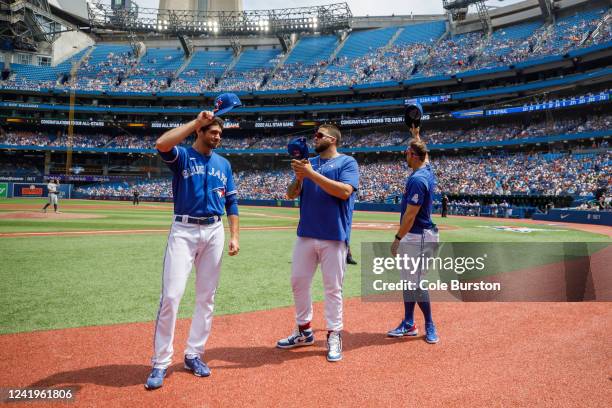 Jordan Romano, Alek Manoah and George Springer of the Toronto Blue Jays salute the crowd as their announced over the loud speaker they'll be heading...