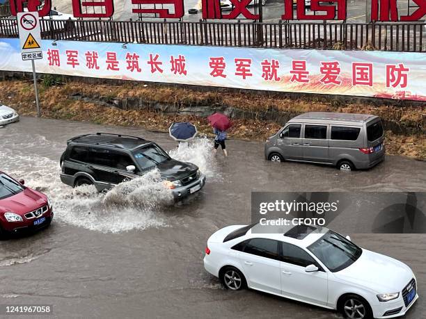 Cars drive through water caused by torrential rain on Chongqing Road in Chongqing, China, July 18, 2022.