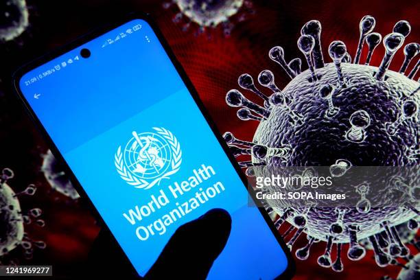 In this photo illustration, the World Health Organization logo is seen displayed on an android mobile phone with a covid illustration in the...