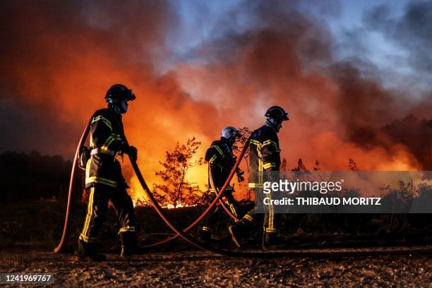 Firefighters try to control a forest fire in Louchats, south-western France, on July 17, 2022.