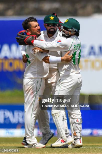 Pakistan's Yasir Shah celebrates with teammates after taking the wicket of Sri Lanka's Kusal Mendis during the third day of play of the first cricket...