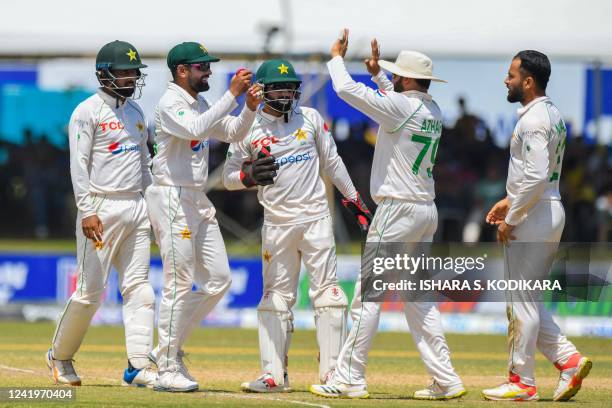 Pakistans captain Babar Azam and teammates celebrate after taking the wicket of Sri Lanka's Angelo Mathews during the third day of play of the first...