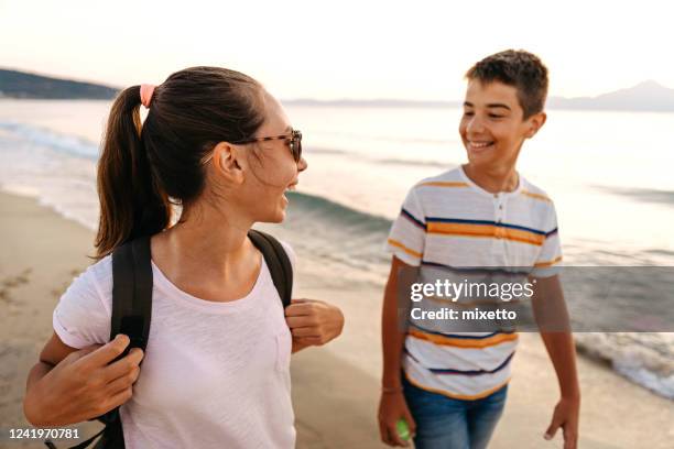 amigos caminando por la playa - boy and girl talking fotografías e imágenes de stock