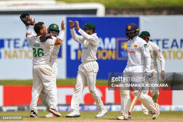 Pakistan's Yasir Shah celebrates with teammates after taking the wicket of Sri Lanka's Dhananjaya de Silva during the third day of play of the first...