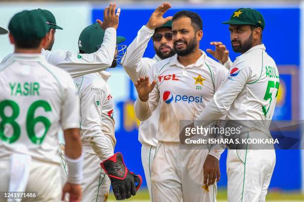 Pakistans Mohammad Nawaz celebrates with teammates after taking the wicket of Sri Lanka's Ramesh Mendis during the third day of play of the first...