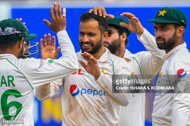 Pakistans Mohammad Nawaz celebrates with teammates after taking the wicket of Sri Lanka's Ramesh Mendis during the third day of play of the first...